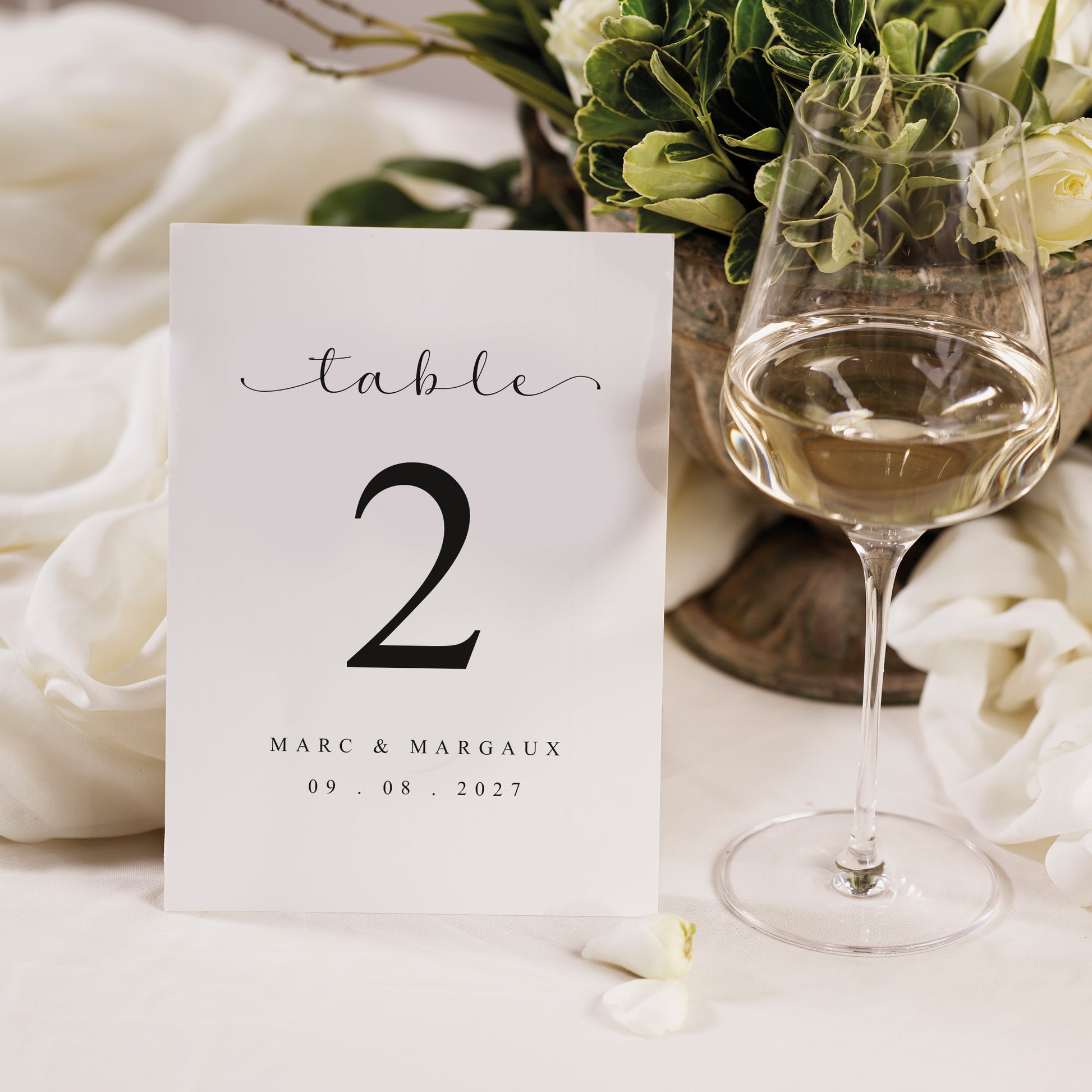 Numéros de table mariage disposés sur tables décor élégant